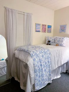 a white bed sitting next to a window in a bedroom