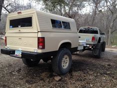 the truck is parked on the side of the road in the woods next to another vehicle