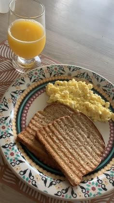 a breakfast plate with eggs, toast and orange juice