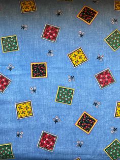 a blue background with small squares and flowers on it's sides, all in different colors