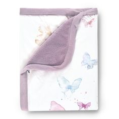 a blanket with butterflies on it and a purple border around the edges is laying flat