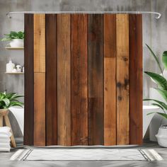 a shower curtain made out of wood planks in a bathroom with potted plants