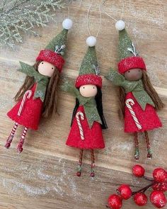 three little christmas elves hanging from a tree