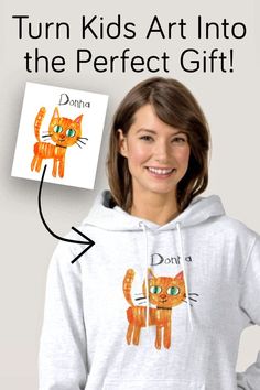 a girl wearing a white hoodie with an orange cat drawn on it and the words, turn kids art into the perfect gift