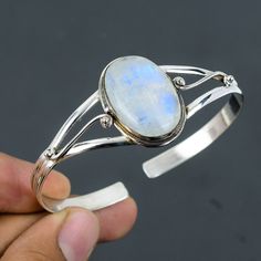 Note: Due to the natural formation of this gemstone. Slight variation in design and color are to be expected. Rainbow Moonstone Bangle 925 Sterling Silver Bangle Adjustable Cuff Bracelet Handmade Designer Bangle Natural Gemstone Jewelry Gift For Him SKU  : VC-56 Handmade Cuff Bracelet Gemstone : Rainbow Moonstone Stone Shape : Oval Metal Purity : 925 Sterling Silver Cuff Bracelet Size : Adjustable Rainbow moonstone is thought to bring balance, harmony and hope while enhancing creativity, compassion, endurance and inner confidence. Rainbow moonstone is believed to help strengthen intuition and psychic perception, especially offering us visions of things that aren't immediately obvious. Payalcreations is committed to delivering the best quality sterling silver jewelry to customers. As a hand Sterling Silver Oval Gemstone Cuff Bracelet, Oval Sterling Silver Gemstone Cuff Bracelet, Elegant Moonstone Cuff Bangle Bracelet, Elegant Moonstone Bangle Cuff Bracelet, Sterling Silver Cuff Bracelet With Natural Stones, Moonstone Gemstone Cuff Bracelet Bangle, Silver Oval Bangle With Gemstone, Cuff Bracelets Handmade, The Bangles