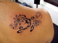 the back of a woman's shoulder with a tattoo design on her left side