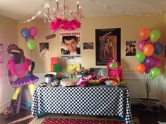 a birthday party with balloons, cake and pictures on the wall in the background is a checkered tablecloth