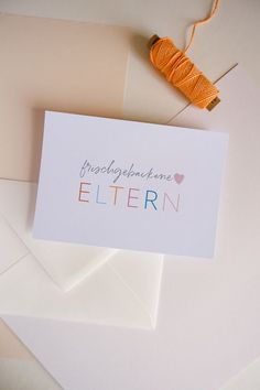 a card with the words congratulations written on it next to some thread and envelopes