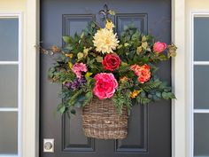 a basket filled with flowers hanging from the side of a door