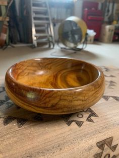 a wooden bowl sitting on top of a table