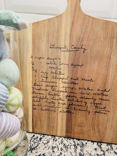 a wooden cutting board with writing on it next to some stuffed animals and other items