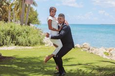 a man and woman are dancing in front of the ocean