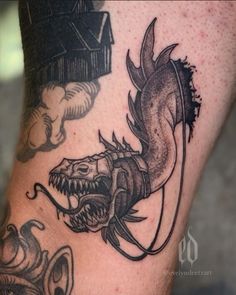 a close up of a person's leg with tattoos on it and a dragon