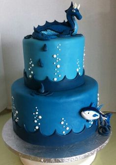 a three tiered cake with blue frosting and sea creatures on it's sides