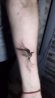 a small bird tattoo on the arm