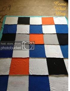 a quilt made to look like a checkerboard pattern with orange, blue and black squares