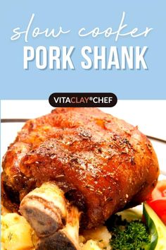 pork shank on a plate with vegetables and sauce in the background text reads slow cooker pork shank