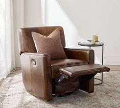 a brown recliner chair sitting on top of a rug next to a glass table