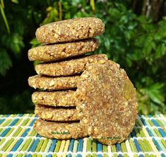 a stack of cookies sitting on top of a blue and green table cloth with trees in the background