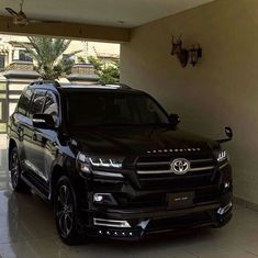 a black suv parked in front of a garage with two deer heads on the wall