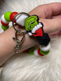 the grinch key chain is being held by someone's hand