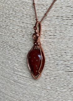 Gemstone: Red Stone. Not sure what kind. It's a beautiful mystery! Cut: Teardrop Cabochon. Length: 2 inches. Width: 3/4 inches. Wire Material: Bare Copper Satellite chain: 18 inches. Lobster closure. Copper. FREE ITEMS INCLUDED: Satellite chain and yellow polishing cloth. Care: I always recommend you keep ALL jewelry away from water, so take this off before showering and swimming. Due to the delicate, handmade nature of this piece, be sure to avoid wearing during activities in which the piece ca Bohemian Rust Necklaces For Gift, Earthy Red Jewelry For Gifts, Bohemian Teardrop Hand Wrapped Necklaces, Bohemian Hand Wrapped Teardrop Necklace, Rust Teardrop Handmade Jewelry, Bohemian Rust-colored Jewelry For Gifts, Earthy Red Handmade Jewelry, Earthy Red Jewelry With Natural Stones, Bohemian Teardrop Carnelian Jewelry