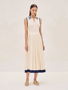 The Ciele Midi Dress is a perfect blend of elegance and comfort. Its collar and button detail give a subtle nod to classic style, while the ivory flows into a pleated midi skirt trimmed with a broad, marine blue hem that adds just the right amount of contrast. It's a versatile piece that works for both office settings and weekend brunches. Pair it with sandals for a relaxed yet sophisticated look. Classic White Pleated Midi Dress, Elegant Cream Dress With Pleated Skirt, Cream Pleated A-line Midi Dress, Cream Pleated Knee-length Midi Dress, Cream A-line Pleated Midi Dress, Knee-length Pleated Cream Midi Dress, Elegant White Midi Dress With Accordion Pleats, Classic Navy Spring Dress, Chic Cream Pleated Dress