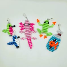 four beaded keychains in different colors and designs on a white table top