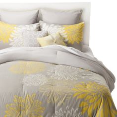 a bed with yellow and gray comforters on it