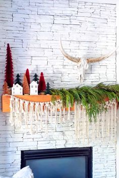 a mantel with christmas decorations and deer heads on it