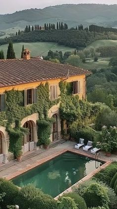 an aerial view of a house with a pool in the foreground and mountains in the background