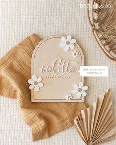 a close up of a wooden sign on a table with paper fans and other items