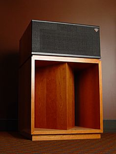 an empty wooden box sitting on top of a carpeted floor next to a wall