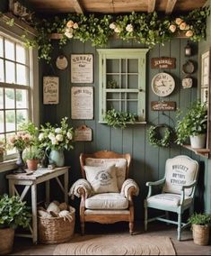 a room with green walls and lots of plants on the windows sill, chairs and tables