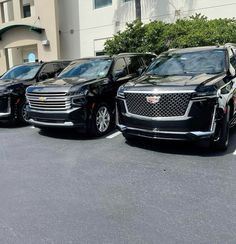 three cadillac suvs are parked in a parking lot