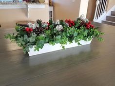 a white planter filled with plants on top of a wooden table