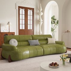 a living room with a green couch and white rug