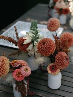 flowers are arranged in vases on a table