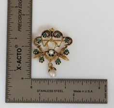 "This is a 14K Yellow Gold Floral Emerald & Pearl set Brooch, 8 Emeralds & Pearl Prong set with Pearl Suspension, 1.5\" height, Circa 1950, weight 6.8 grams Stock # BB95L09 This listing contains photographs of the actual item you will receive. Our items are in excellent condition with little or no signs of wear and many are one of a kind pre-owned estate finds. Please look closely at the pictures in this listing as they are part of the product description. Please read the description, as Victorian Gold Brooches With Jewels, Antique Jeweled Brooches For Formal Occasions, Heirloom Pendant Brooch For Wedding, Antique Pendant Brooches For Anniversary, Victorian Jeweled Formal Brooches, Heirloom Pendant Brooches For Weddings, Victorian Jeweled Brooches For Anniversary, Traditional Hallmarked Brooches For Anniversary, Antique Jeweled Brooches For Wedding