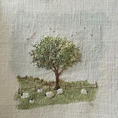 a piece of art with sheep and a tree on it