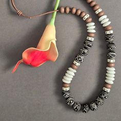 This is a wonderfully bold necklace with neutral tones but nonetheless big on personality.  It is on an adjustable leather cord and can go from 24 to 30 inches in length. I've used several beads from Africa, including the Terracotta Mali Clay handcrafted beads,  carved bone beads, and glass saucer beads. Adjustable White Earthy Necklaces, White Adjustable Earthy Necklaces, Adjustable White Earthy Necklace, White Adjustable Earthy Necklace, Casual Brown Necklace With Adjustable Cord, Bohemian Beaded Necklaces For Everyday, Brown Necklace With Adjustable Cord For Festivals, Adjustable Brown Necklace With Black Beads, Adjustable Brown Necklace With Large Beads