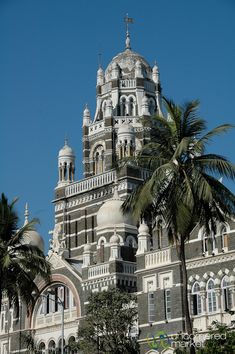 an ornate building with palm trees in the foreground