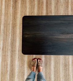 a person standing in front of a table with their feet on the floor next to it