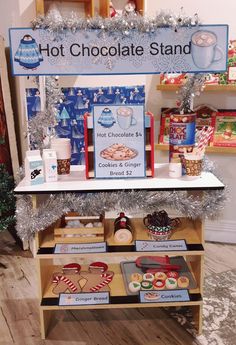 a hot chocolate stand with cookies and gingerbreads on it's display shelf