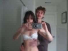 a man and woman taking a selfie in front of a mirror with their reflection