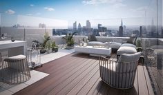 an outdoor living area with couches, tables and chairs on a deck overlooking the city