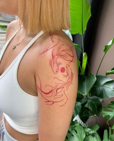 a woman with a dragon tattoo on her upper arm and shoulder is looking at the camera