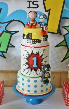 a three tiered cake with cartoon characters on it's top and the number one