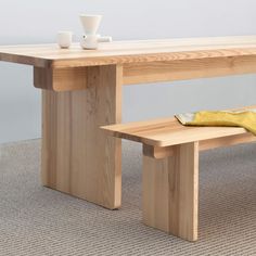 a wooden table with two benches next to it and a cup on the table top