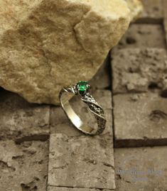 a close up of a stone with a ring on it and a rock in the background